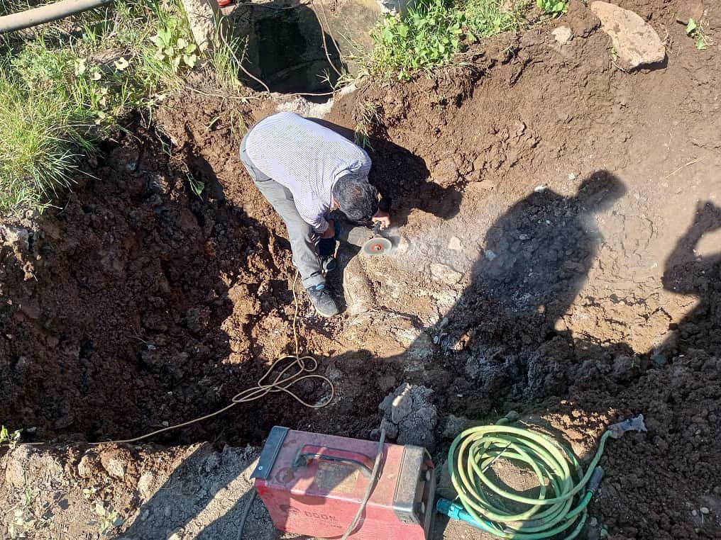 Clearing a blockage and fixing a problem in an irrigation line in the town of Qusayba